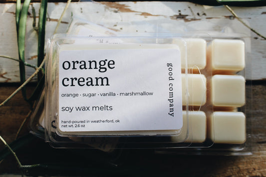 A package of Good Company soy wax melts in the scent 'Orange Cream', showing several cream-colored wax cubes in a clear plastic clamshell container with a white label.